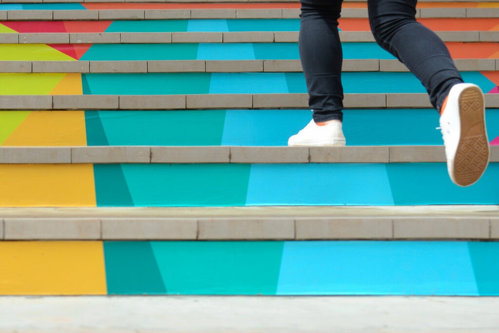 homme jean monte escalier coloré