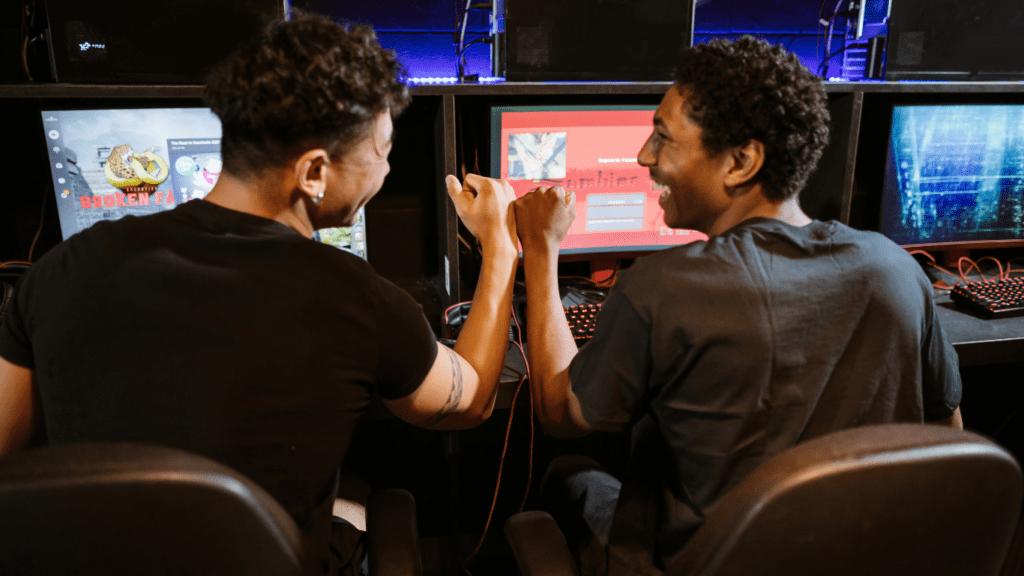 Deux homme qui se tapent la main devant leur ordinateur.