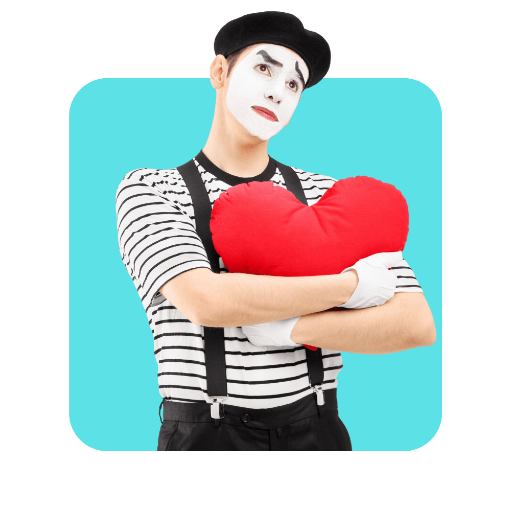 Clown avec chapeau noir, pull rayé noir et blanc bretelles noires serrant un coeur en peluche rouge - se former aux soft skills