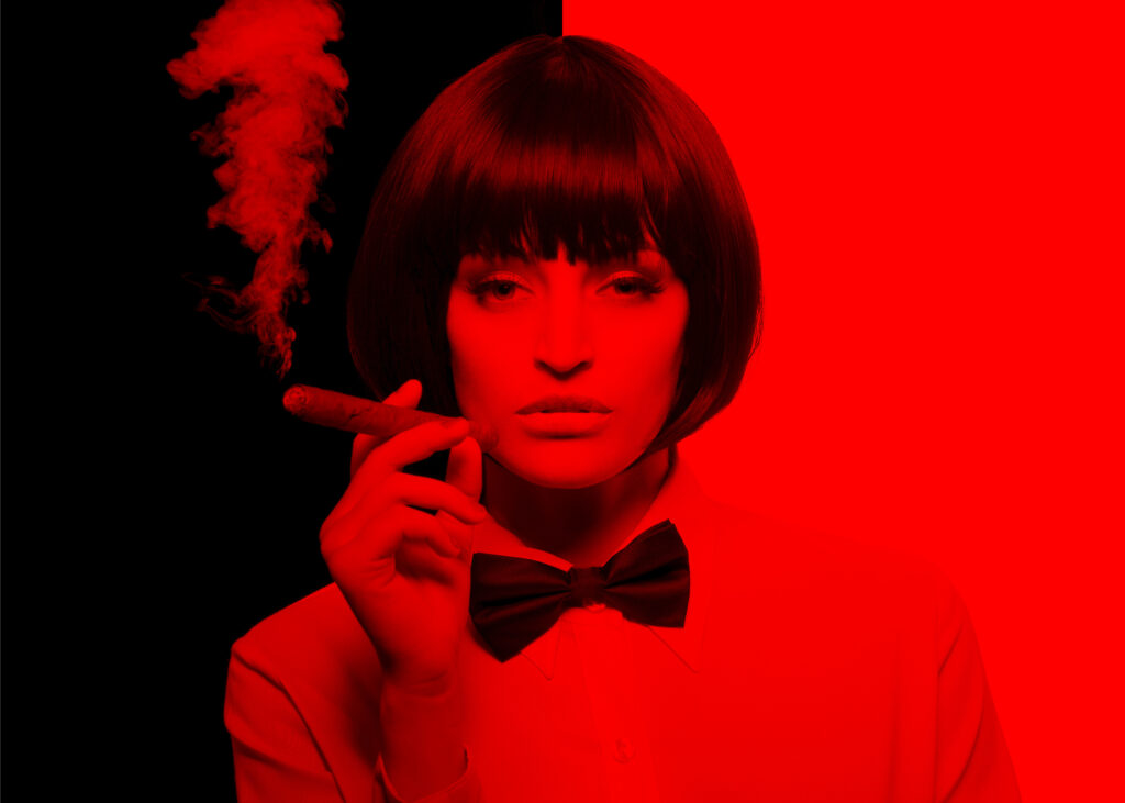 Femme avec chemise blanche et noeud papillon noir, cigare à la main avec un filtre rouge - gérer les conflits grâce à l'hybrid learning