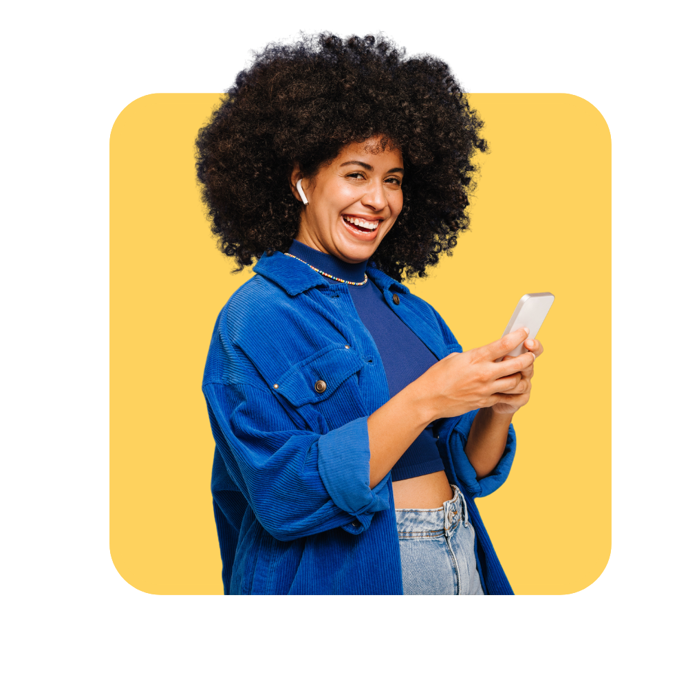 Femme afro souriante avec sont téléphone et chemise en jean sur fond jaune - gestion des émotions